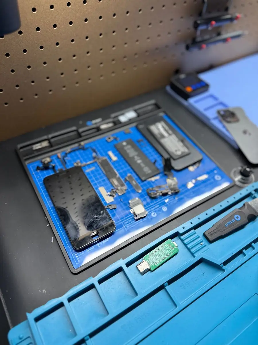 iPhone opened for battery replacement with parts laid out at OneClick Phone Repairs in Fullerton, CA